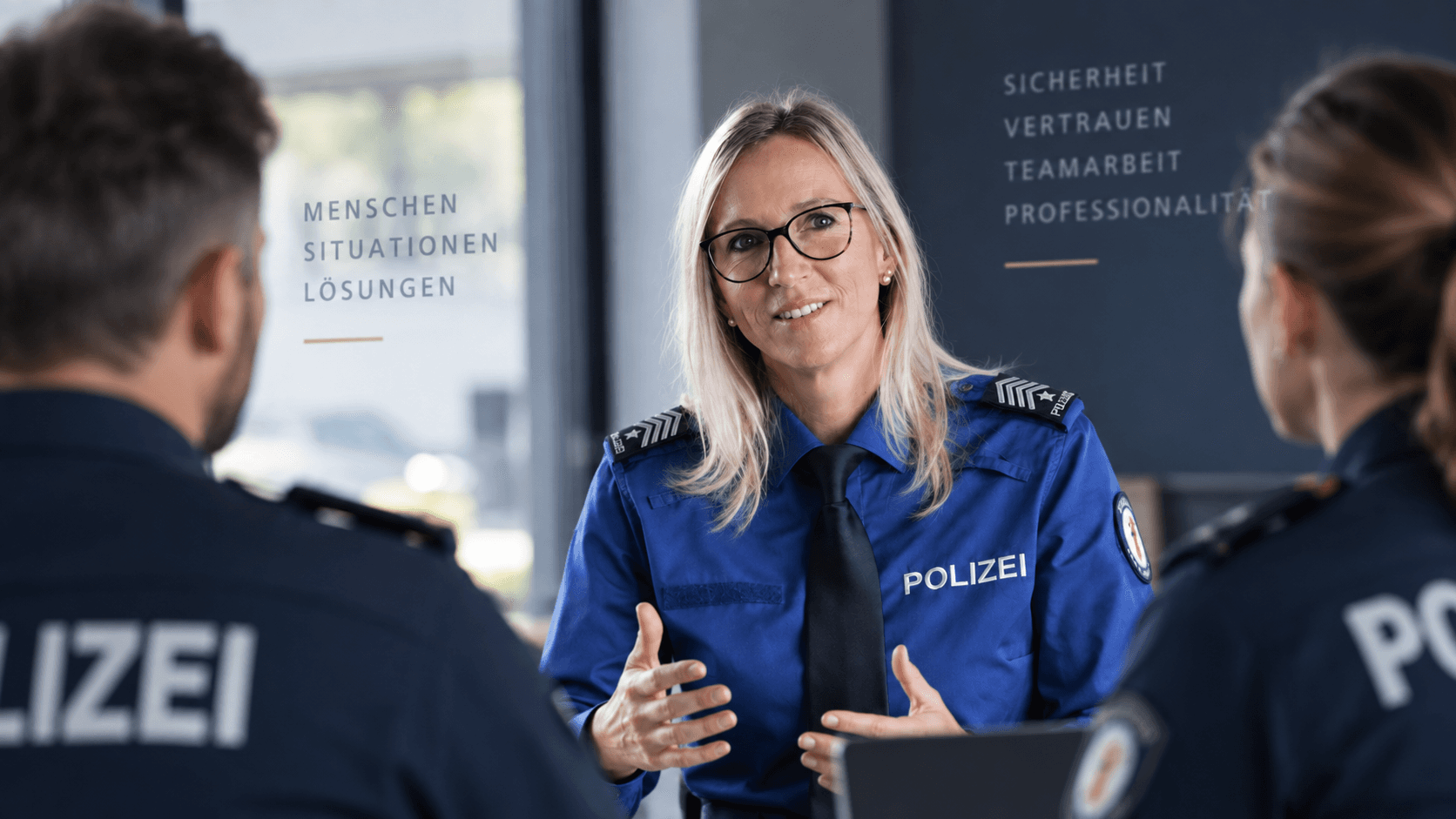 Claudia Räber-Abegg in Polizeiuniform im Gespräch mit zwei Polizisten